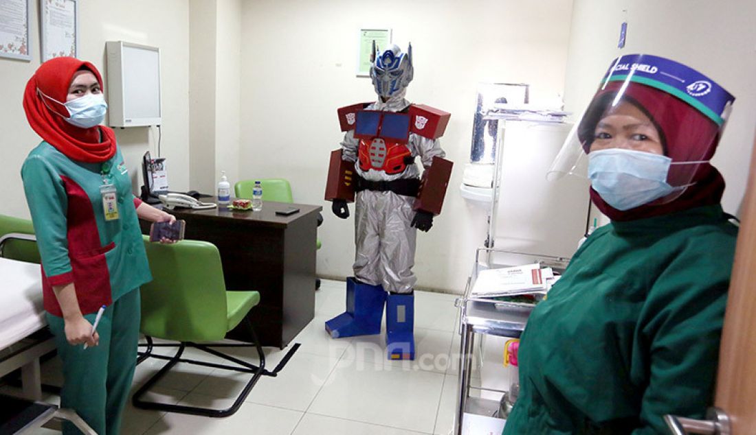 Dokter Rollando Erric Manibuy, SpOT mengenakan APD berkostum Transformer di RS Vania, Bogor, Jumat (22/5). Pemakian APD berkostum unik itu dilakukan agar pasien tetap terus optimis meghadapi Corona. - JPNN.com