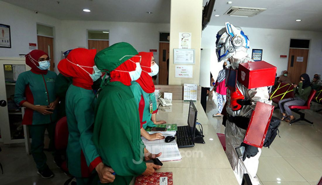 Dokter Rollando Erric Manibuy, SpOT mengenakan APD berkostum Transformer di RS Vania, Bogor, Jumat (22/5). Pemakian APD berkostum unik itu dilakukan agar pasien tetap terus optimis meghadapi Corona. - JPNN.com