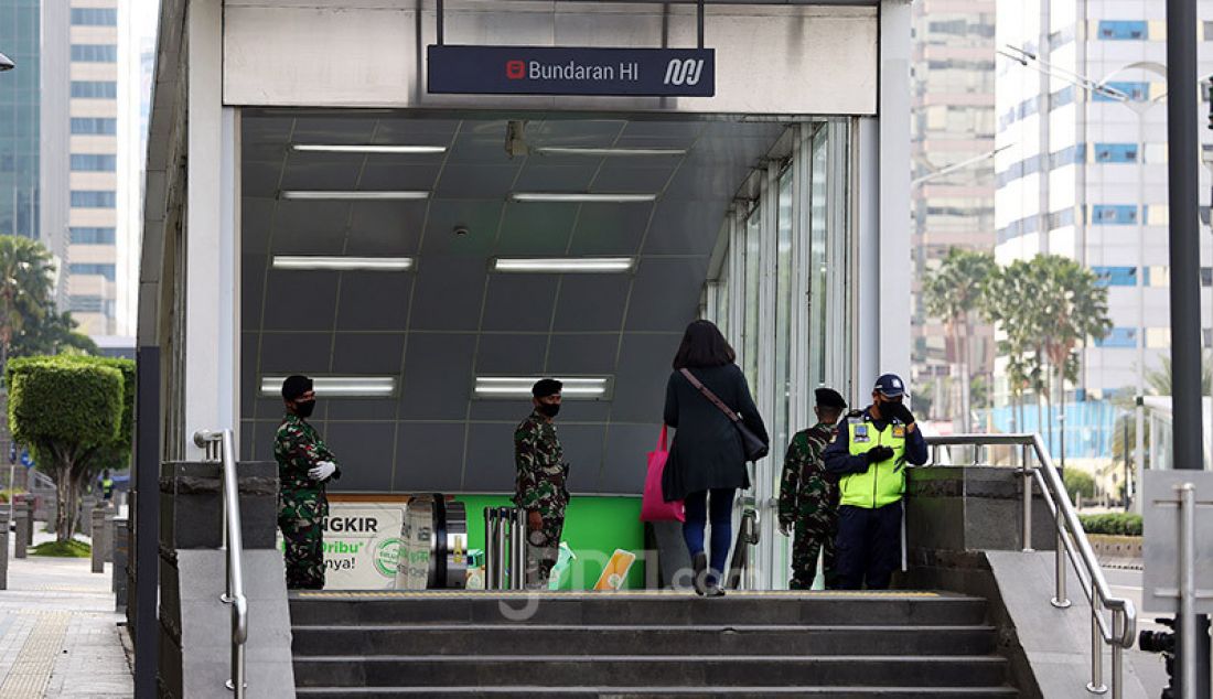 Anggota TNI berjaga di pintu masuk Halte Bus Transjakarta Bunderan HI, Jakarta, Rabu (27/5). Pemerintah akan segera menerapkan kebijakan di tempat keramaian yang akan kembali buka dan rencananya diterapkan minggu depan. - JPNN.com