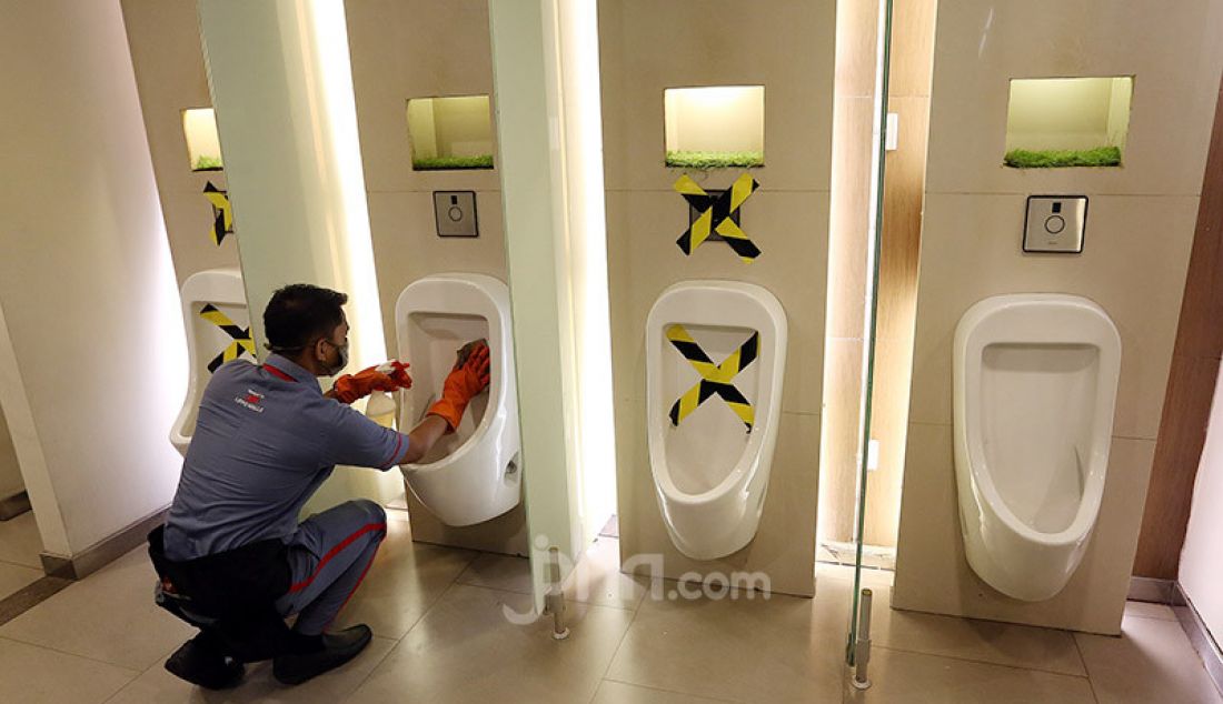 Petugas membersihkan urinoar atau peturasan di Lippo Mall Kemang, Jakarta, Selasa (2/6). Menjelang penerapan New Normal, Lippo Mall Kemang melakukan pembenahan dan penerapan protokol kesehatan. - JPNN.com