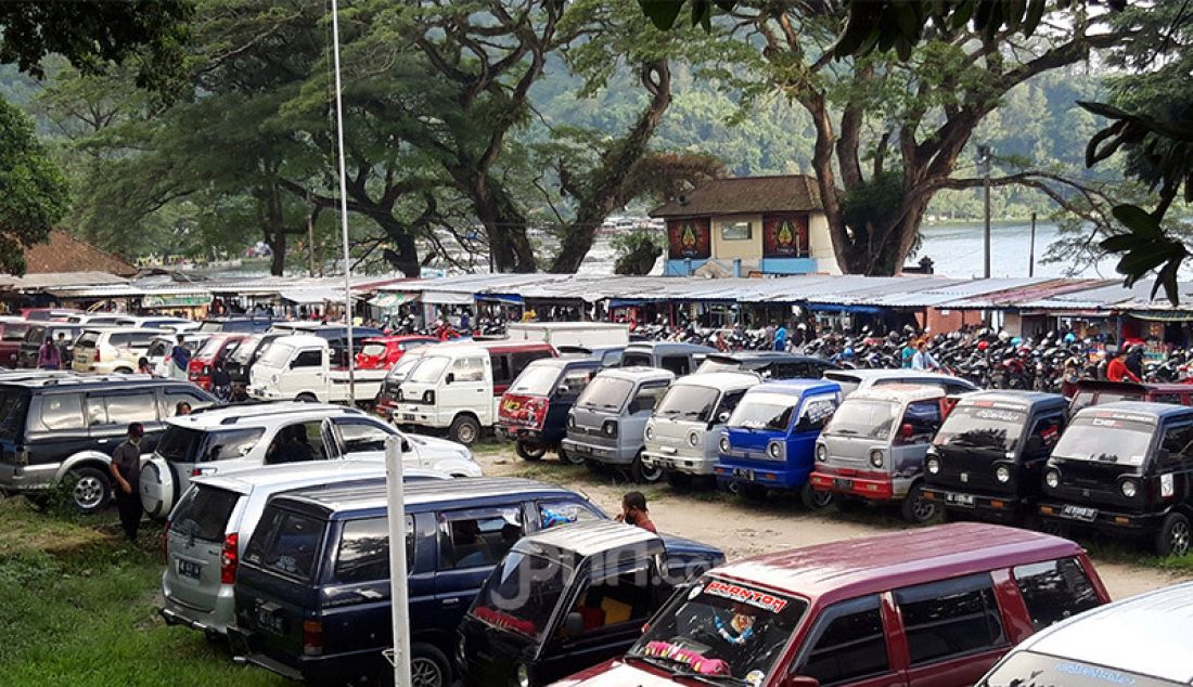 Area parkir Telaga Ngebel dipenuhi kendaraan wisatawan yang berkunjung semenjak diberlakukannya status New Normal, Minggu (7/6). Kawasan wisata alam yang ada di wilayah timur Kabupaten Ponorogo ini telah dibuka pada awal bulan Juni 2020. - JPNN.com