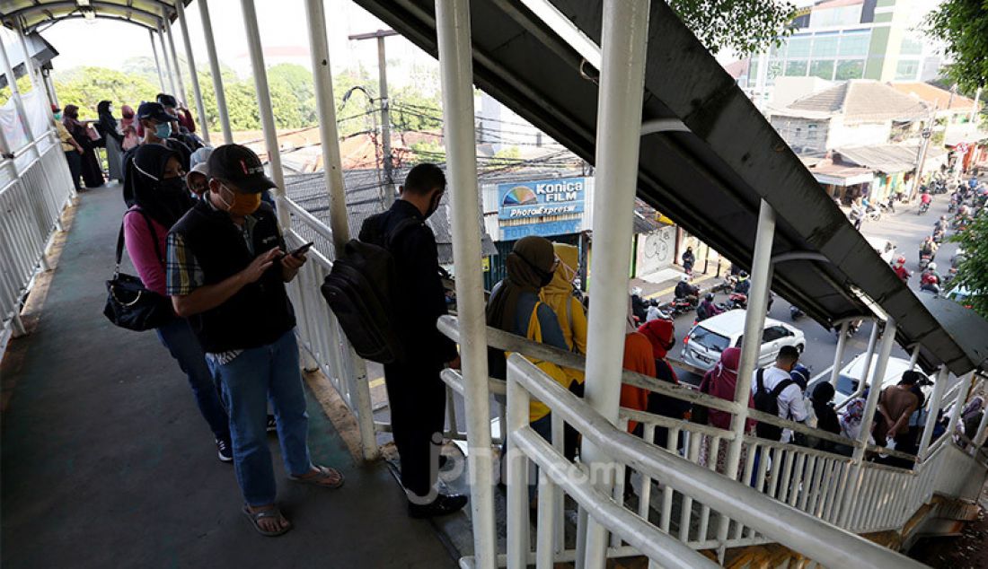 Calon penumpang KRL saat mengantri di luar stasiun Lenteng Agung, Jakarta, Senin (8/6). Mereka mengantri karena adanya pembatasan penumpang. - JPNN.com