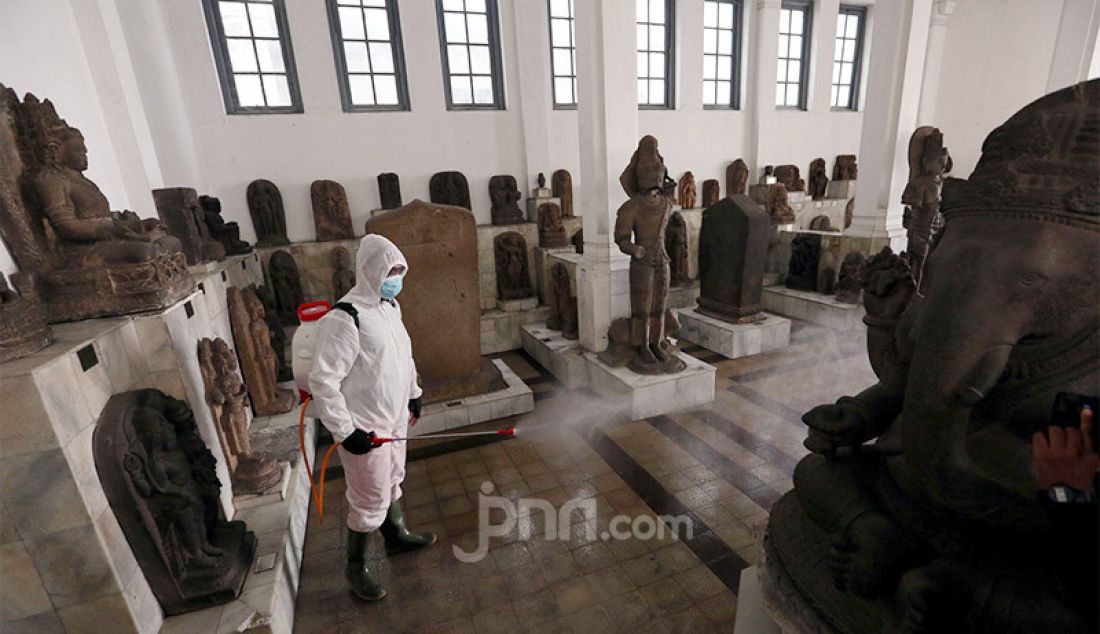 Petugas Palang Merah Indonesia (PMI) menyemprotkan disinfektan di Museum Nasional, Jakarta, Senin (8/6). Pemprov DKI Jakarta melanjutkan pembatasan sosial berskala besar (PSBB) dengan menetapkan masa transisi di bulan Juni. - JPNN.com