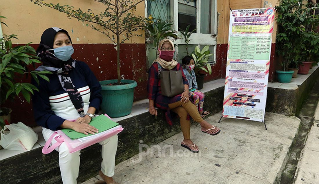 Orang tua siswa saat melakukan pendaftaran peserta didik baru (PPDB) tahun ajaran 2020/2021 di SDN Pengadilan I Bogor, Selasa (9/6). Dinas Pendidikan Kota Bogor membuka waktu pendaftaran PPDB tingkat SD disusul SMP/MTs yang dibagi tiga tahap. - JPNN.com