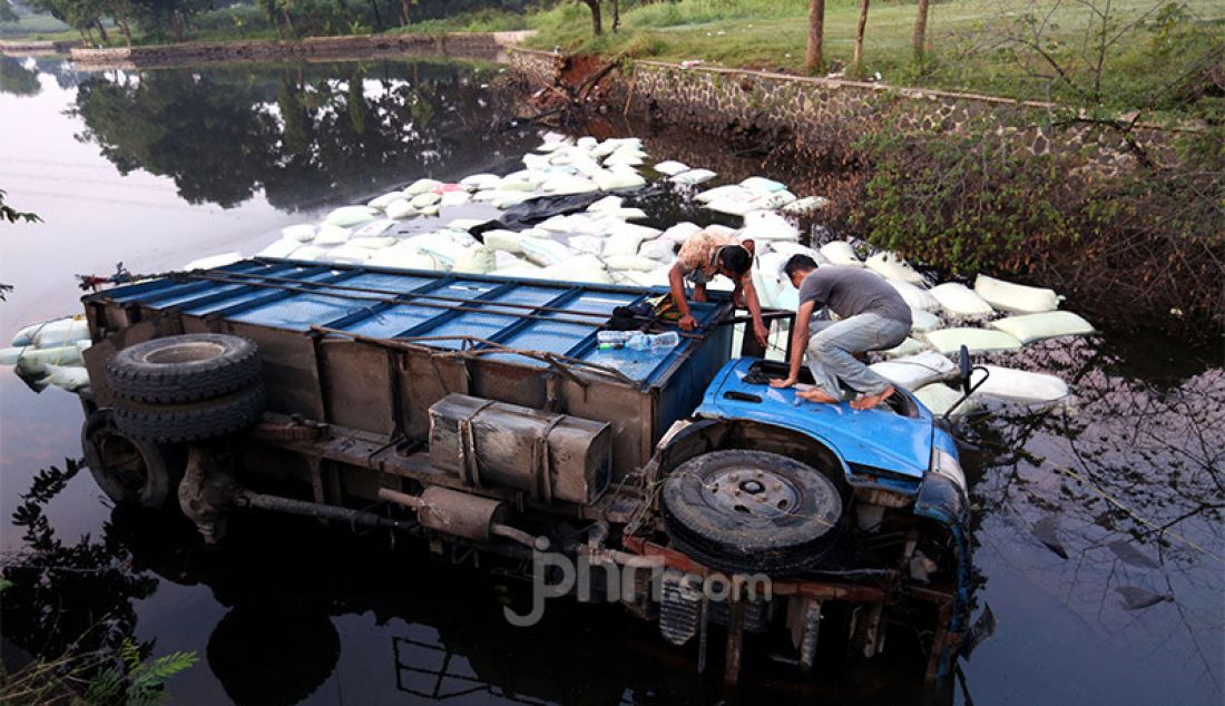 Sebuah truk pengangkut sekam masuk ke dalam Setu Tonjong, Tajur Halang, Kabupaten Bogor, Jawa Barat, Selasa (9/6). Kejadian tersebut pada waktu subuh dikarenakan pengemudi mengantuk. - JPNN.com
