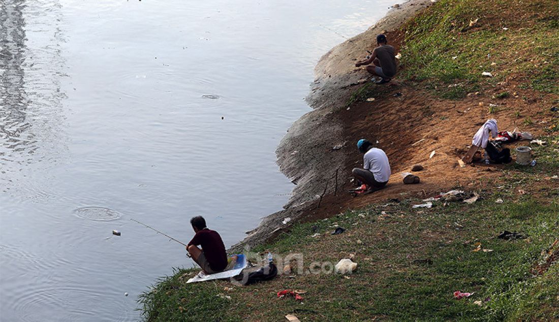 Warga melakukan aktivitas memancing di Kanal Banjir Barat, Jakarta, Selasa (9/6). Fase pertama PSBB transisi di Ibukota dimanfaatkan sejumlah warga untuk aktivitas memancing. - JPNN.com