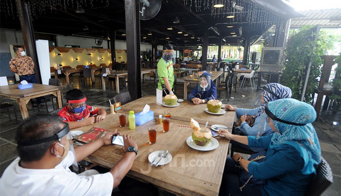 Pengunjung dengan mengenakan pelindung wajah (Face Shield) menikmati makanan di Restoran Bandar Djakarta, Alam Sutra, Tangsel, Banten, Rabu (10/6). - JPNN.com