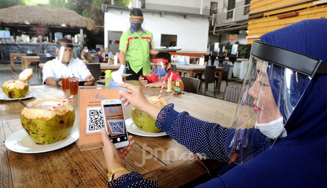 Pengunjung dengan mengenakan pelindung wajah (Face Shield) menikmati makanan di Restoran Bandar Djakarta, Alam Sutra, Tangsel, Banten, Rabu (10/6). - JPNN.com