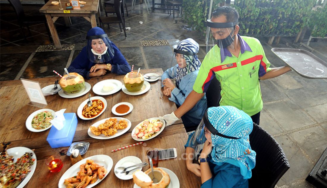 Pengunjung dengan mengenakan pelindung wajah (Face Shield) menikmati makanan di Restoran Bandar Djakarta, Alam Sutra, Tangsel, Banten, Rabu (10/6). - JPNN.com