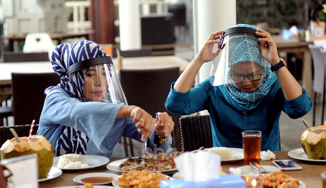 Pengunjung dengan mengenakan pelindung wajah (Face Shield) menikmati makanan di Restoran Bandar Djakarta, Alam Sutra, Tangsel, Banten, Rabu (10/6). - JPNN.com