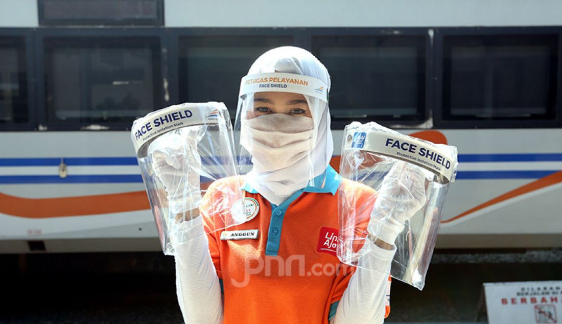 Petugas PT Kereta Api Indonesia (Persero) Daop I Jakarta menyiapkan Face Shield (pelindung muka, red) untuk penumpang kereta di Stasiun Pasar Senen, Jakarta, Jumat (12/6). PT KAI secara resmi kembali mengoperasikan kereta api - JPNN.com