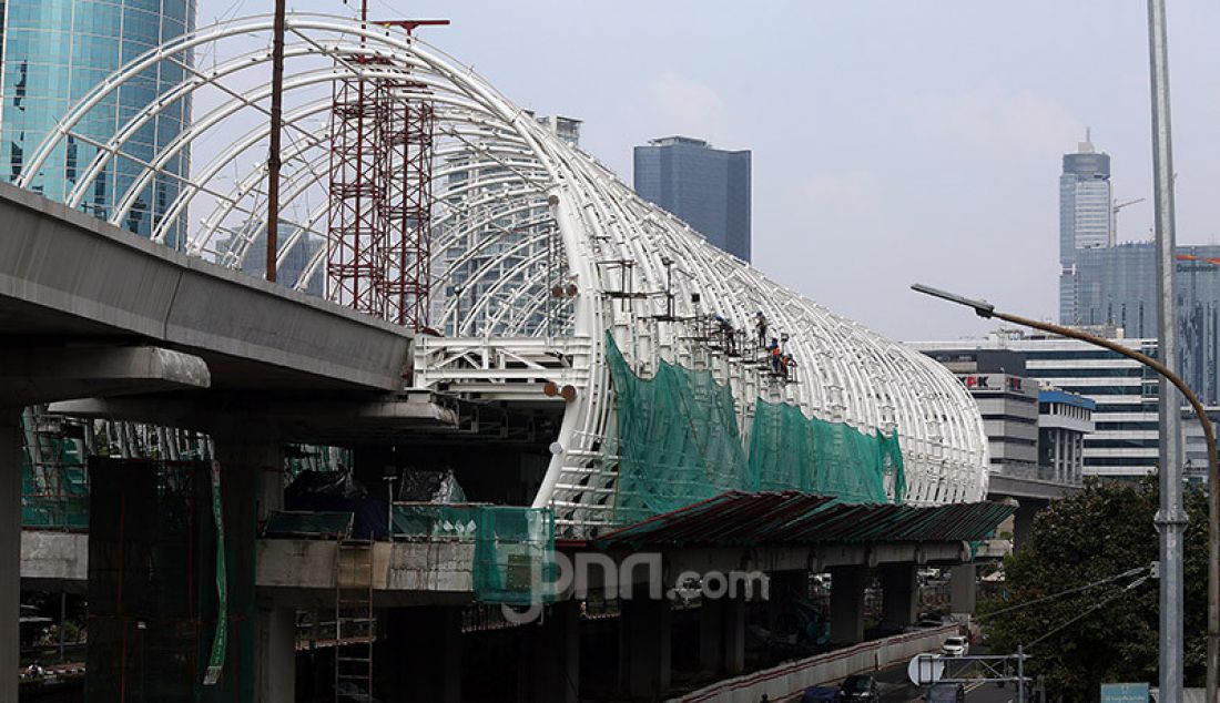 Pekerja menyelesaikan proyek Stasiun LRT Jabodebek dan long span ruas Kuningan-Dukuh Atas, Jakarta, Jumat (12/6). Stasiun tersebut nantinya akan terkoneksi dengan kawasan terpadu TOD yang menggabungkan moda transportasi MRT Ratangga, kereta commuter line, kereta bandara, dan bus Transjakarta. - JPNN.com