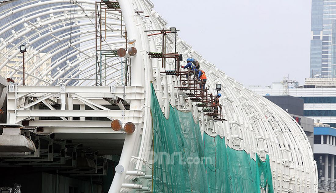 Pekerja menyelesaikan proyek Stasiun LRT Jabodebek dan long span ruas Kuningan-Dukuh Atas, Jakarta, Jumat (12/6). Stasiun tersebut nantinya akan terkoneksi dengan kawasan terpadu TOD yang menggabungkan moda transportasi MRT Ratangga, kereta commuter line, kereta bandara, dan bus Transjakarta. - JPNN.com