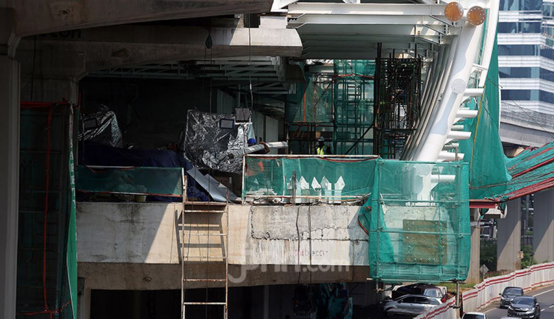 Pekerja menyelesaikan proyek Stasiun LRT Jabodebek dan long span ruas Kuningan-Dukuh Atas, Jakarta, Jumat (12/6). Stasiun tersebut nantinya akan terkoneksi dengan kawasan terpadu TOD yang menggabungkan moda transportasi MRT Ratangga, kereta commuter line, kereta bandara, dan bus Transjakarta. - JPNN.com