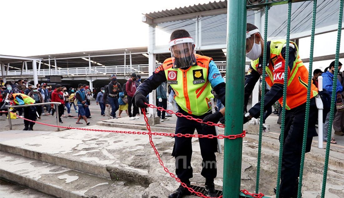 Petugas memasang pembatas antrian calon penumpang KRL di Stasiun Bogor, Jawa Barat, Senin (15/6). Pemasangan pembatas tersebut untuk mengatur jalur penumpang dan penerapan pembatasan fisik. - JPNN.com