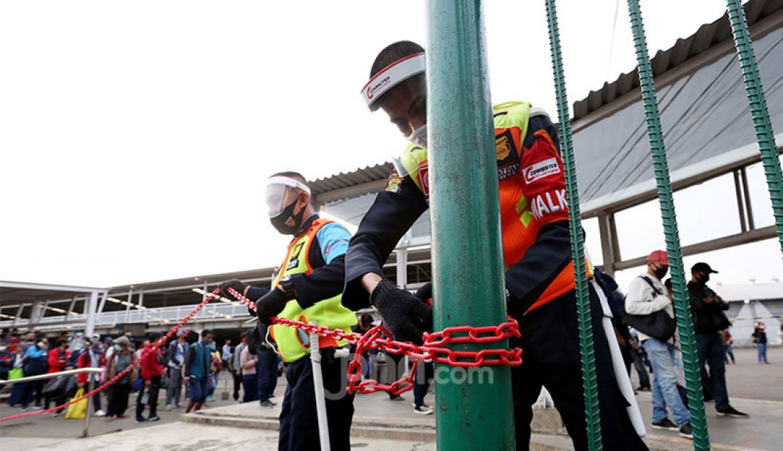 Petugas memasang pembatas antrian calon penumpang KRL di Stasiun Bogor, Jawa Barat, Senin (15/6). Pemasangan pembatas tersebut untuk mengatur jalur penumpang dan penerapan pembatasan fisik. - JPNN.com