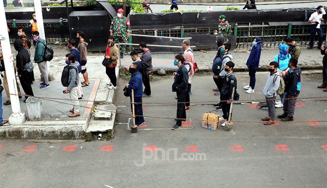 Penumpang mengantre dengan menjaga jarak di Stasiun Bogor, Jawa Barat, Senin (15/6). Stasiun Bogor menjadi salah satu tempat yang menerapkan protokol kesehatan. - JPNN.com