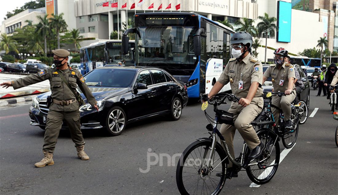 Gubernur DKI Jakarta, Anies Baswedan bersama Wagub Ahmad Riza Patria bersepeda bersama menuju kantor Balaikota, Jakarta, Selasa (16/6). - JPNN.com