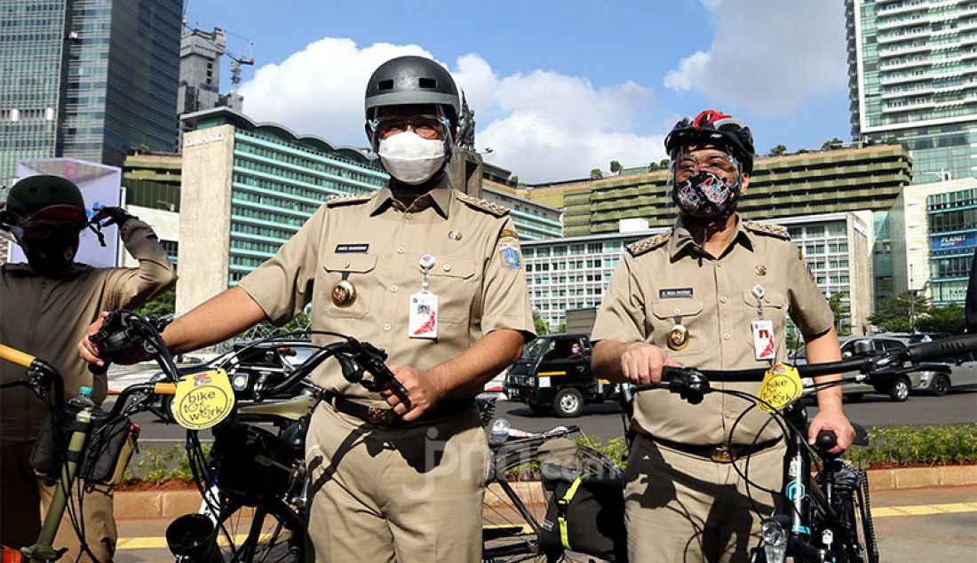 Gubernur DKI Jakarta, Anies Baswedan bersama Wagub Ahmad Riza Patria bersepeda bersama menuju kantor Balaikota, Jakarta, Selasa (16/6). - JPNN.com