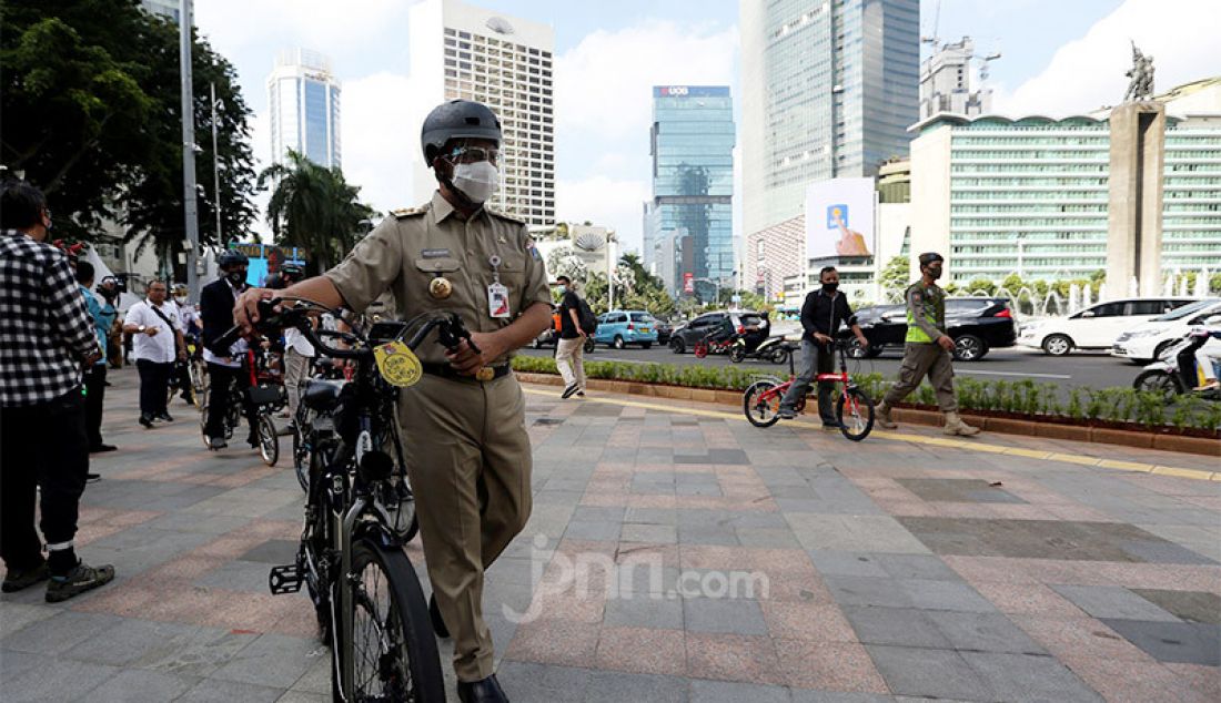 Gubernur DKI Jakarta, Anies Baswedan bersama Wagub Ahmad Riza Patria bersepeda bersama menuju kantor Balaikota, Jakarta, Selasa (16/6). - JPNN.com