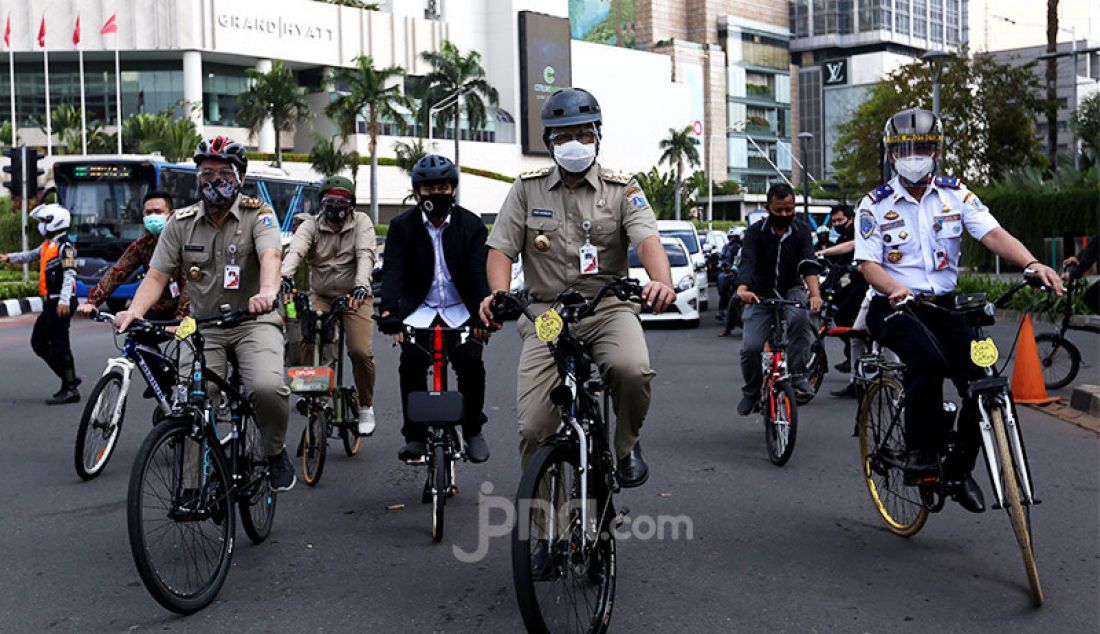 Gubernur DKI Jakarta, Anies Baswedan bersama Wagub Ahmad Riza Patria bersepeda bersama menuju kantor Balaikota, Jakarta, Selasa (16/6). - JPNN.com