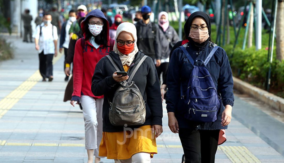 Sejumlah pekerja mengenakan masker di Kawasan Sudirman, Jakarta, Selasa (16/6). Gugus Tugas Percepatan Penanganan Covid-19 menerbitkan surat edaran yang mengatur waktu kerja karyawan di wilayah Jabodetabek untuk mengurai kepadatan pengguna transportasi. - JPNN.com