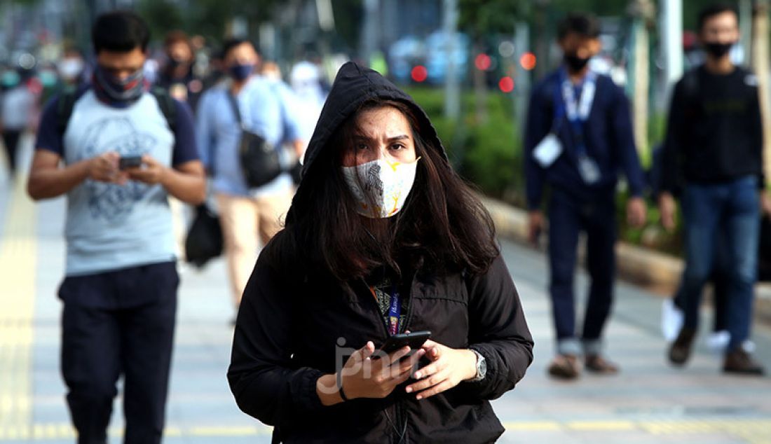 Sejumlah pekerja mengenakan masker di Kawasan Sudirman, Jakarta, Selasa (16/6). Gugus Tugas Percepatan Penanganan Covid-19 menerbitkan surat edaran yang mengatur waktu kerja karyawan di wilayah Jabodetabek untuk mengurai kepadatan pengguna transportasi. - JPNN.com