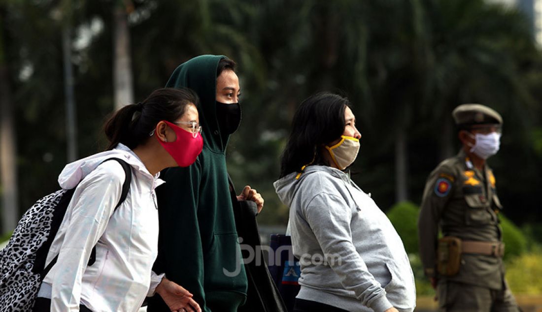 Sejumlah pekerja mengenakan masker di Kawasan Sudirman, Jakarta, Selasa (16/6). Gugus Tugas Percepatan Penanganan Covid-19 menerbitkan surat edaran yang mengatur waktu kerja karyawan di wilayah Jabodetabek untuk mengurai kepadatan pengguna transportasi. - JPNN.com