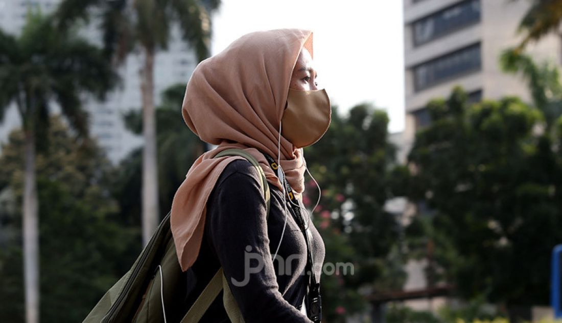 Sejumlah pekerja mengenakan masker di Kawasan Sudirman, Jakarta, Selasa (16/6). Gugus Tugas Percepatan Penanganan Covid-19 menerbitkan surat edaran yang mengatur waktu kerja karyawan di wilayah Jabodetabek untuk mengurai kepadatan pengguna transportasi. - JPNN.com