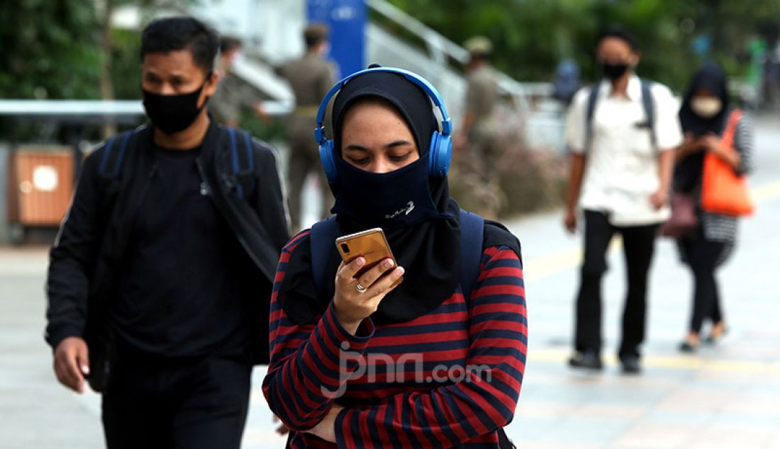 Sejumlah pekerja mengenakan masker di Kawasan Sudirman, Jakarta, Selasa (16/6). Gugus Tugas Percepatan Penanganan Covid-19 menerbitkan surat edaran yang mengatur waktu kerja karyawan di wilayah Jabodetabek untuk mengurai kepadatan pengguna transportasi. - JPNN.com