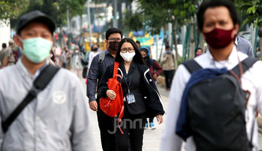 Sejumlah pekerja mengenakan masker di Kawasan Sudirman, Jakarta, Selasa (16/6). Gugus Tugas Percepatan Penanganan Covid-19 menerbitkan surat edaran yang mengatur waktu kerja karyawan di wilayah Jabodetabek untuk mengurai kepadatan pengguna transportasi. - JPNN.com