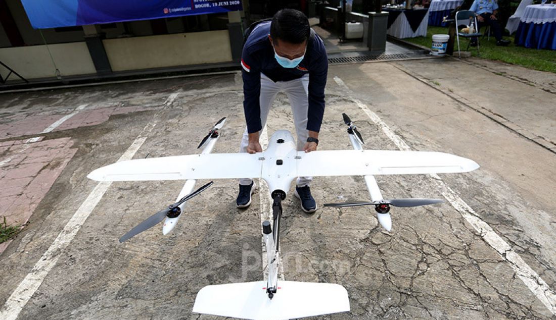 Seorang pilot drone binaan TNI AU saat mempersiapkan demonstrasi drone VTOL, Pabuaran, Kemang, Bogor, Jumat (19/6). Drone dimanfaatkan untuk teknologi pertanian dan diharapkan Kecamatan Kemang menjadi percontohan. - JPNN.com