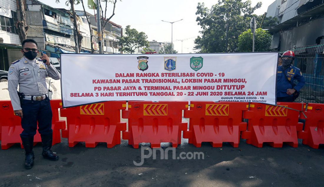 Petugas saat menutup akses masuk ke dalam Pasar Minggu, Jakarta, Sabtu (20/6). Pasar Minggu ditutup selama tiga hari mulai 20-23 Juni 2020 setelah 3 pedagang dinyatakan positif Covid-19. - JPNN.com