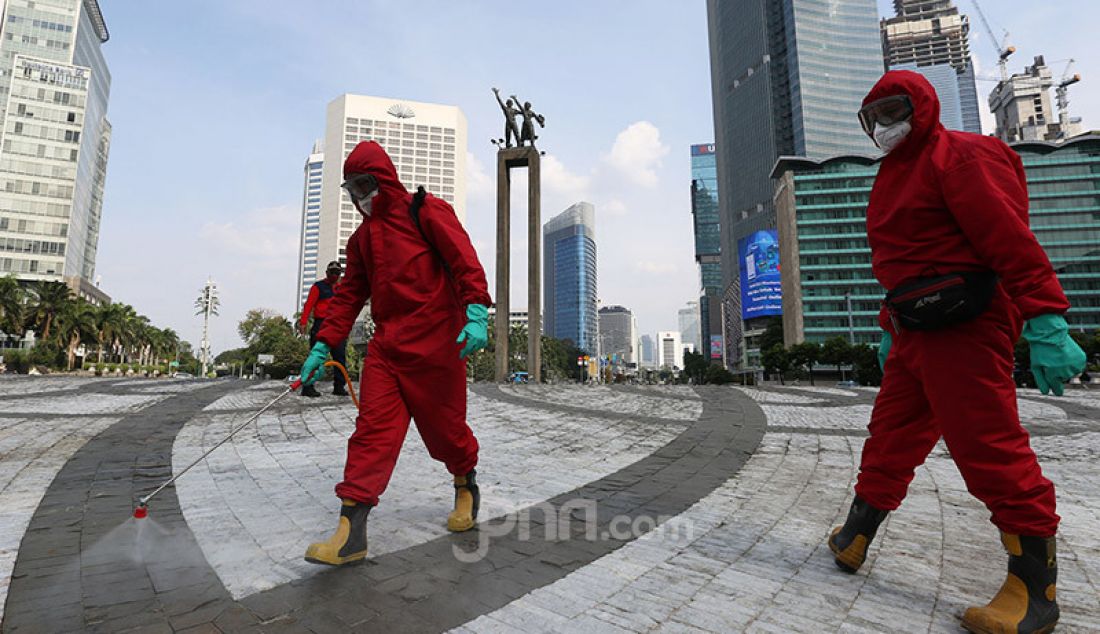 Petugas pemadam kebakaran menyemprotkan cairan disinfektan ke sejumlah fasilitas umum Jakarta, Sabtu (20/6). Penyemprotan cairan disinfektan tersebut dalam rangka persiapan jelang diadakannya kembali hari bebas kendaraan. - JPNN.com