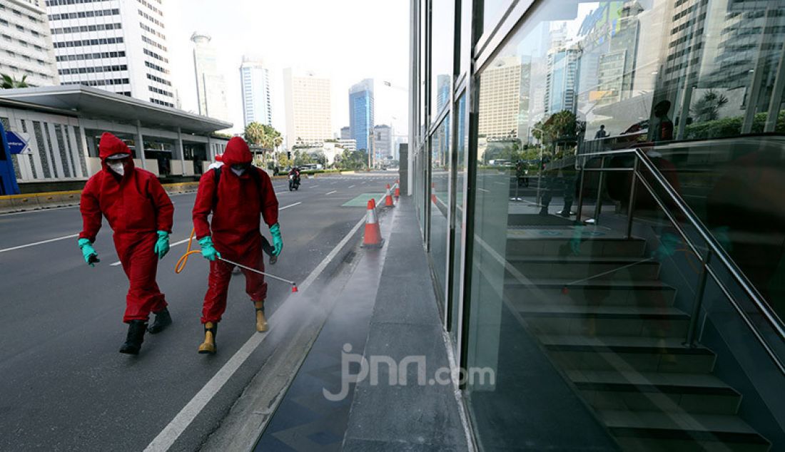 Petugas pemadam kebakaran menyemprotkan cairan disinfektan ke sejumlah fasilitas umum Jakarta, Sabtu (20/6). Penyemprotan cairan disinfektan tersebut dalam rangka persiapan jelang diadakannya kembali hari bebas kendaraan. - JPNN.com