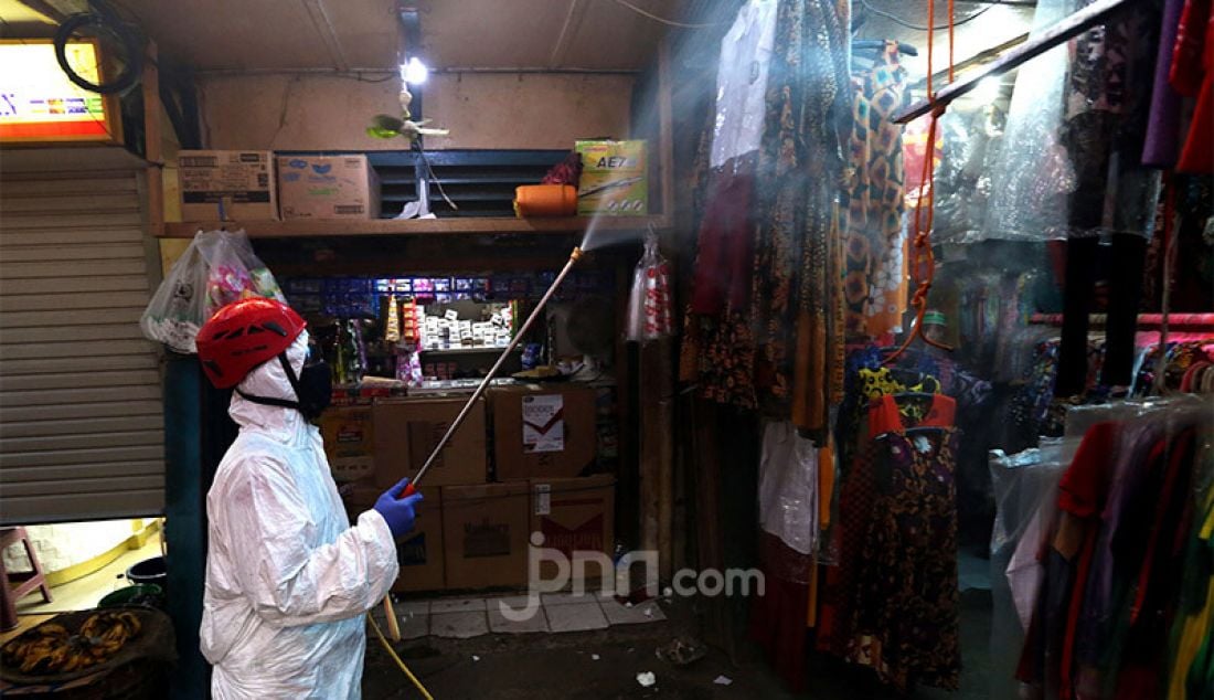 Petugas dari PMI menyemprotkan disinfektan di area Pasar Karang Anyar, Jakarta, Rabu (24/6). Penyemprotan tersebut untuk persiapan swab masal. - JPNN.com