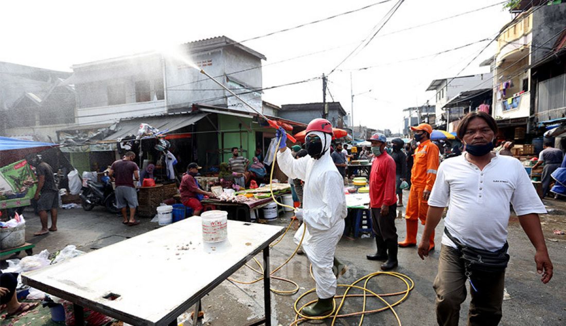 Petugas dari PMI menyemprotkan disinfektan di area Pasar Karang Anyar, Jakarta, Rabu (24/6). Penyemprotan tersebut untuk persiapan swab masal. - JPNN.com