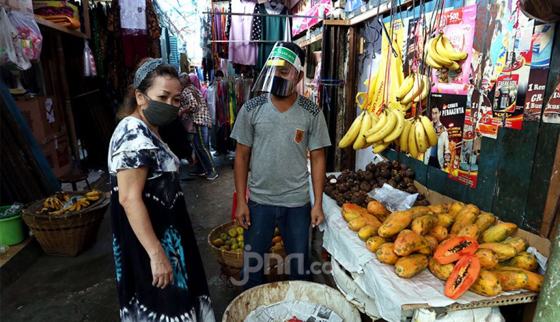 Pedagang memakai face shield dan masker saat melayani pembeli di Pasar Karang Anyar, Jakarta, Rabu (24/6). PD Pasar Jaya wajibkan penggunaan Face Shield dan masker kepada para pedagang untuk mencegah penyebaran Covid 19. - JPNN.com