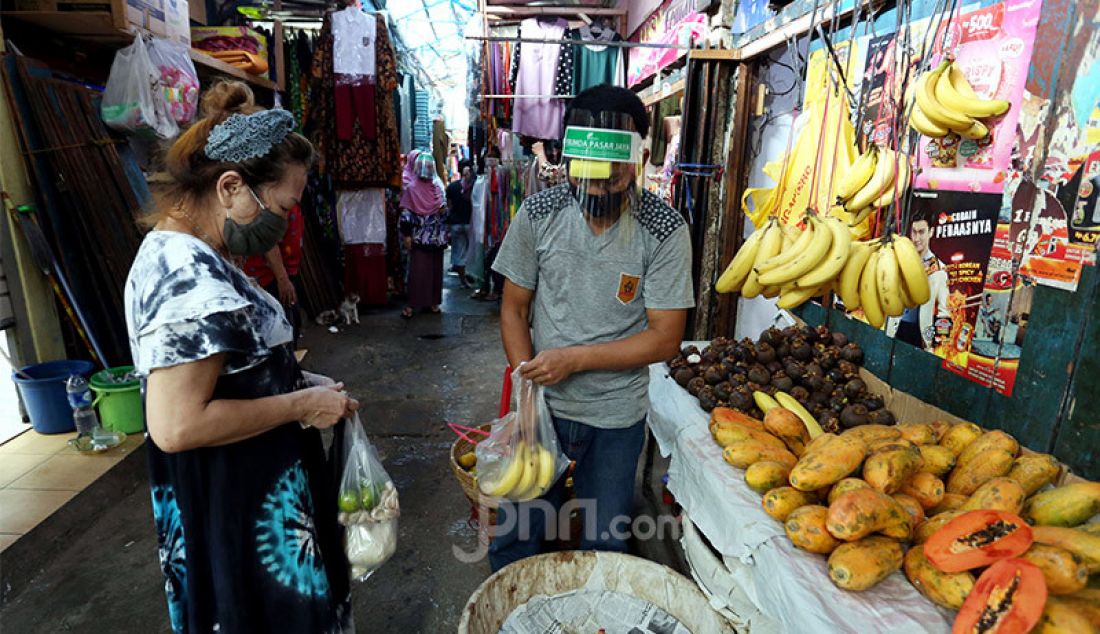 Pedagang memakai face shield dan masker saat melayani pembeli di Pasar Karang Anyar, Jakarta, Rabu (24/6). PD Pasar Jaya wajibkan penggunaan Face Shield dan masker kepada para pedagang untuk mencegah penyebaran Covid 19. - JPNN.com
