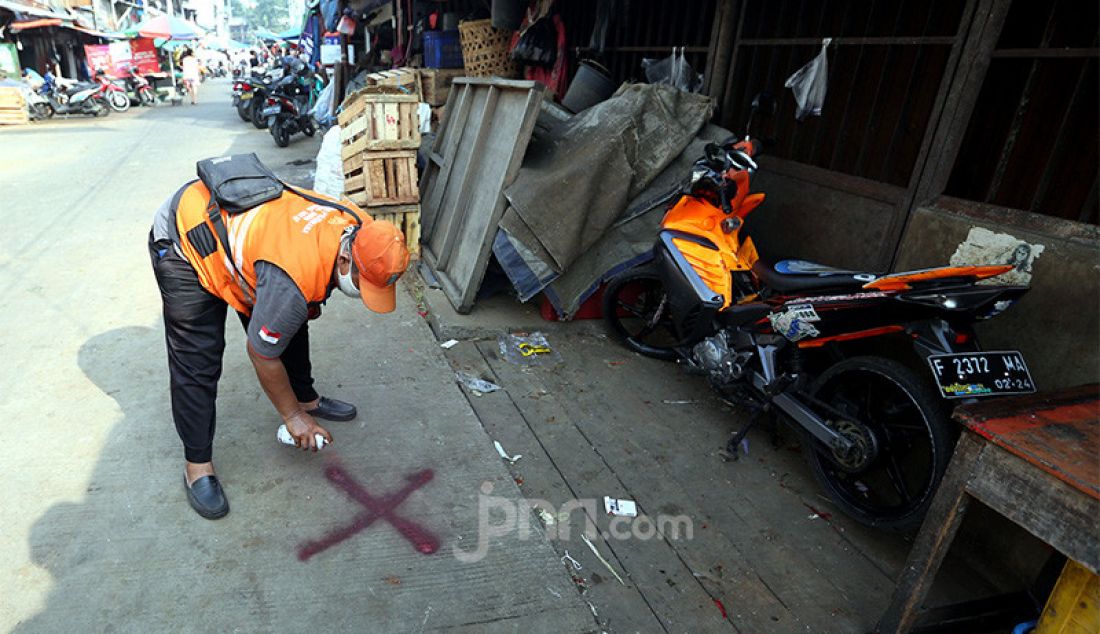 Petugas memberikan tanda silang di depan lapak pedagang Pasar Karang Anyar, Jakarta, Kamis (25/6). Pemberian tanda tersebut untuk pedagang yang tidak mau mengikuti tes swab Covid 19. - JPNN.com