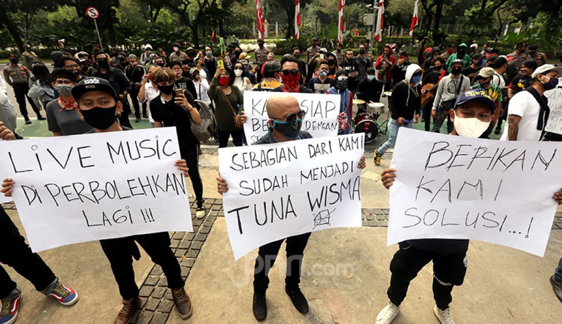 Massa yang tergabung dalam Persatuan Musisi Kafe menggelar unjuk rasa di depan gedung Balai Kota, Jakarta, Rabu (8/7). Mereka menuntut Gubernur DKI Jakarta Anies Baswedan agar mengizinkan penampilan musik di kafe di tengah penerapan Pembatasan Sosial Berskala Besar (PSBB) masa transisi. - JPNN.com