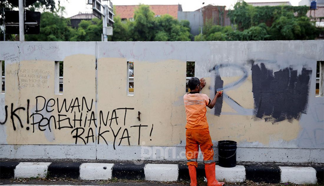 Petugas PPSU membersihkan tulisan vandalisme pasca aksi demo menolak RUU HIP dan RUU Omnibus Law Cipta Kerja di depan Gedung DPR/MPR/DPD, Jakarta, Jumat (17/7). - JPNN.com