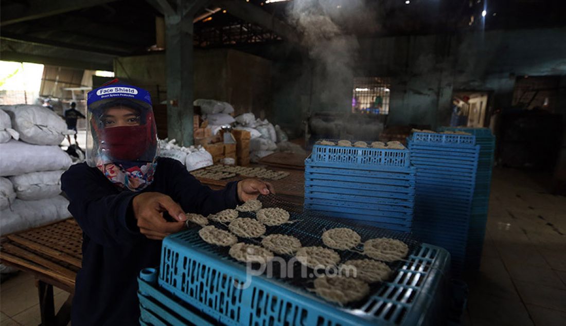 Pekerja usaha kecil menengah kerupuk Pasundan melakukan proses produksi dengan standar protokol kesehatan Covid-19 di pabrik kerupuk Pasundan Bedahan, Sawangan, Depok, Kamis (30/7). Di masa pandemi Covid-19, industri kerupuk Pasundan tidak mengalami dampak penurunan dikarenakan kerupuk ini masih banyak diminati oleh masyarakat. - JPNN.com