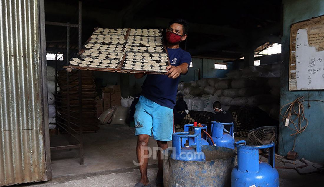 Pekerja usaha kecil menengah kerupuk Pasundan melakukan proses produksi dengan standar protokol kesehatan Covid-19 di pabrik kerupuk Pasundan Bedahan, Sawangan, Depok, Kamis (30/7). Di masa pandemi Covid-19, industri kerupuk Pasundan tidak mengalami dampak penurunan dikarenakan kerupuk ini masih banyak diminati oleh masyarakat. - JPNN.com