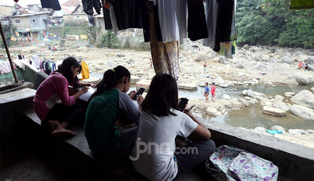 Siswi SMP Persatuan Umat Islam (PUI) Kota Bogor belajar kelompok secara daring di pinggiran sungai Ciliwung, Kampung Kebon Jukut RT 01/10, Kelurahan Babakan Pasar, Kota Bogor, Selasa (4/8). - JPNN.com