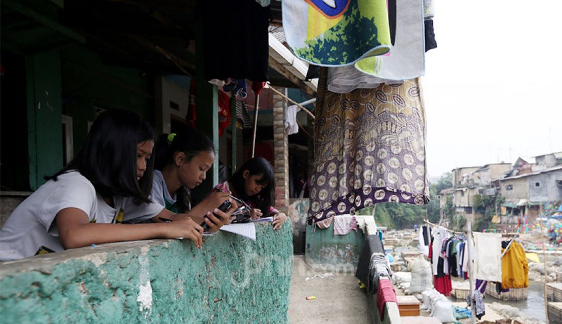 Siswi SMP Persatuan Umat Islam (PUI) Kota Bogor belajar kelompok secara daring di pinggiran sungai Ciliwung, Kampung Kebon Jukut RT 01/10, Kelurahan Babakan Pasar, Kota Bogor, Selasa (4/8). - JPNN.com