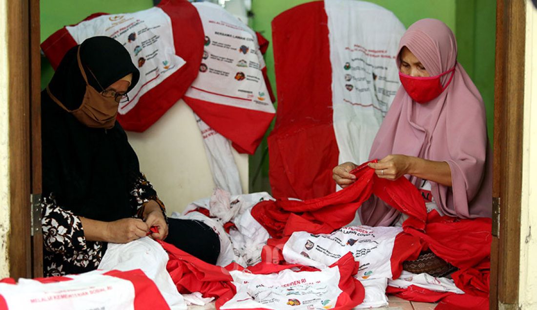 Warga membuat umbul-umbul bendera dari tas bantuan Presiden di Jalan Caringin RT3/1, Kelurahan Bedahan, Kecamatan Sawangan Kota Depok, Kamis (6/8). Mereka mebuat umbul-umbul tersebut untuk menyambut HUT ke 75 Kemerdekaan RI. - JPNN.com