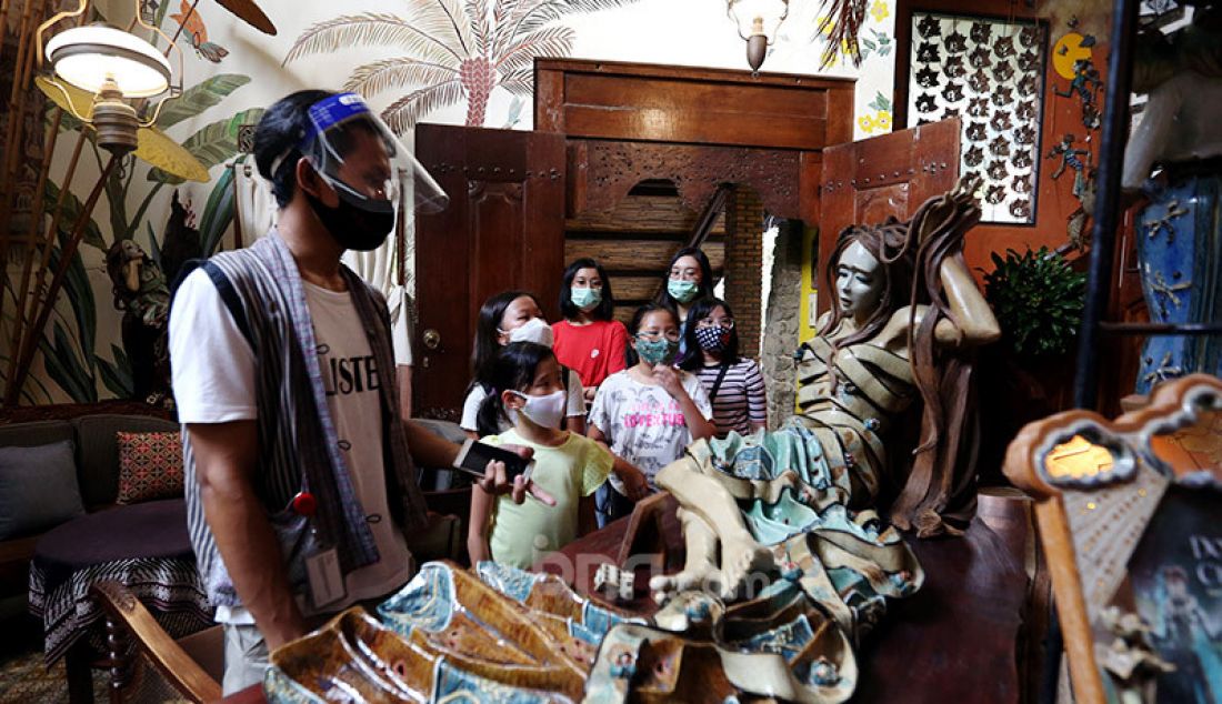 Petugas memakai face shield dan masker saat menunjukkan patung-patung yang terbuat dari keramik kepada anak-anak di museum F. Widayanto Beji, Depok, Kamis (6/8). Sambut new normal masa pandemi covid-19, Wisata edukasi rumah keramik kembali dibuka dengan mematuhi protokol kesehatan. - JPNN.com