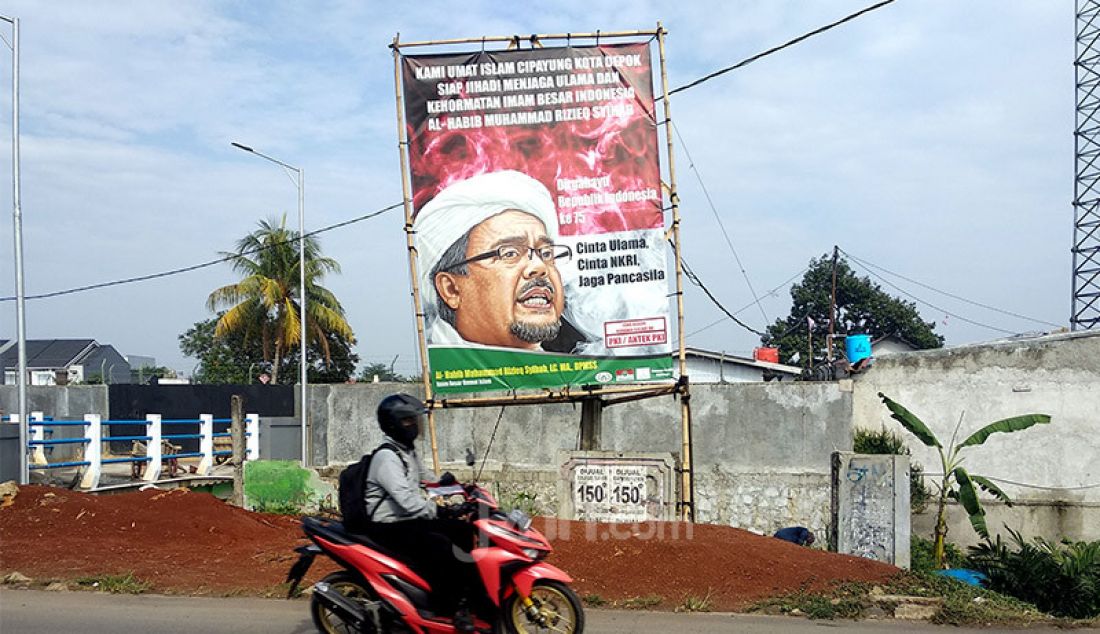 Pengendara sepeda motor melintasi spanduk Habib Rizieq Syihab di Jalan Raya Cipayung Jaya, Depok Jawa Barat, Rabu (12/8). - JPNN.com