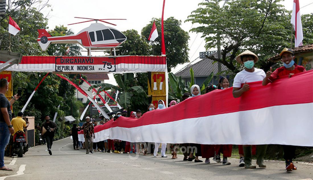 Sejumlah warga membentangkan bendera merah putih sepanjang 200 meter di Desa Cihideung Udik, Ciampea, Kabupaten Bogor, Senin (17/8). Acara tersebut dalam rangka memeriahkan peringatan HUT ke-75 Kemerdekaan Republik Indonesia. - JPNN.com